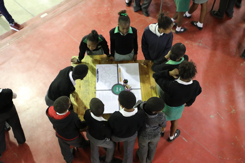 Learners working around a table on a design activity