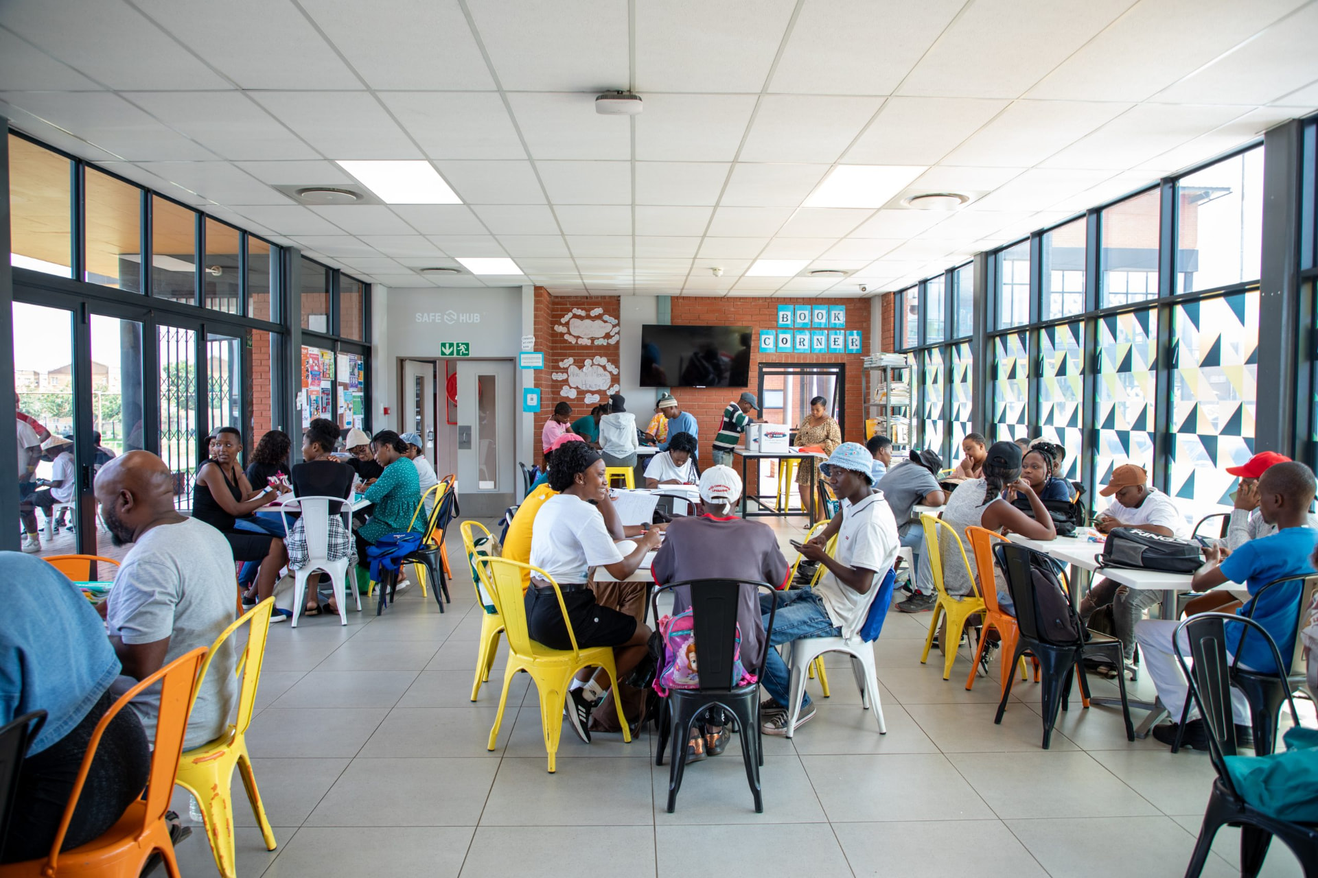 Participants working at tables in a busy DLab learning space