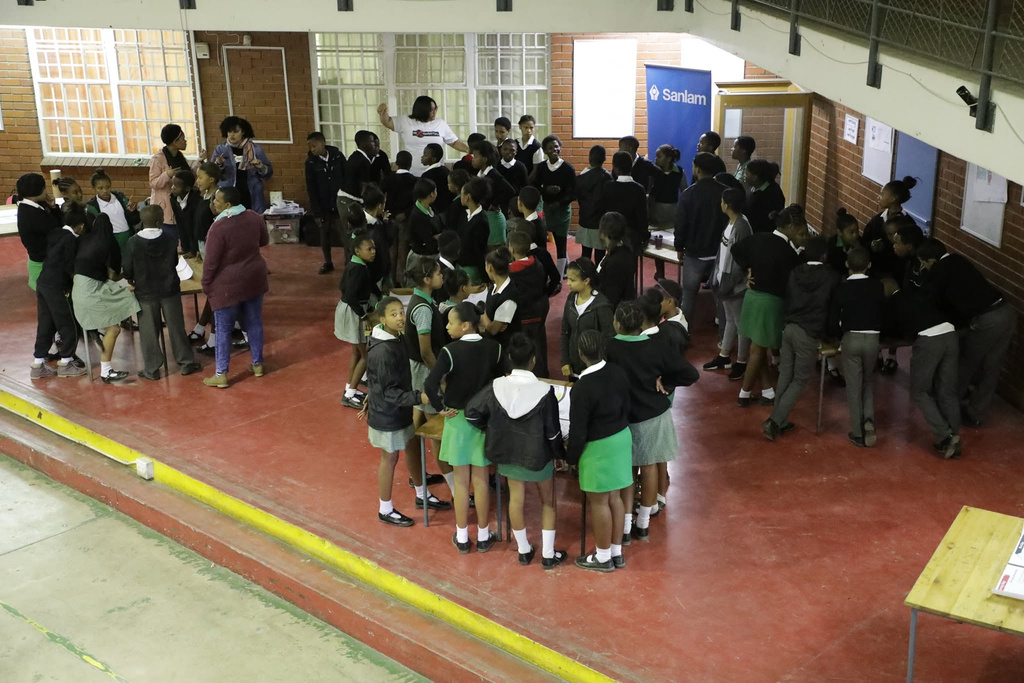 School learners gathered in a hall for a Sanlam Blue Ladder Schools activity
